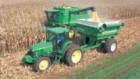 A tractor and trailer in the middle of a field.