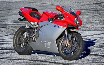 A red and silver motorcycle is parked on the street.