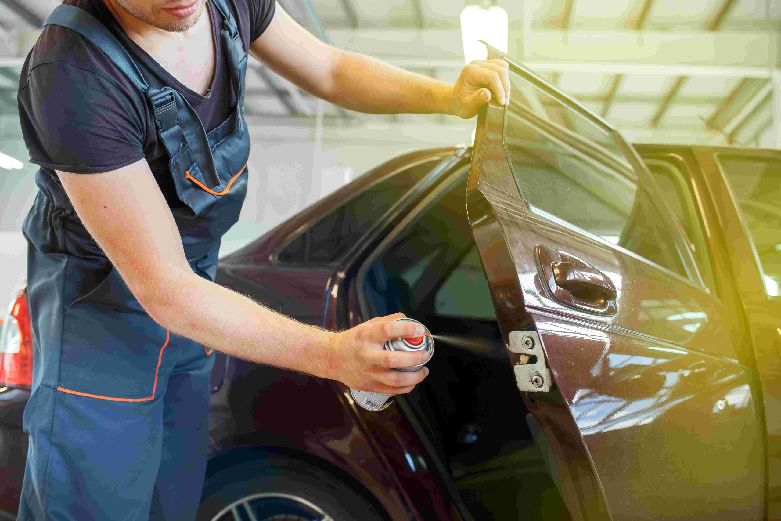 A man is working on the hood of his car.