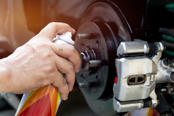 A person is using spray paint to fix the brake.