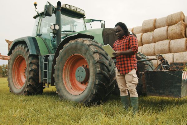 A man standing in front of a tractor.