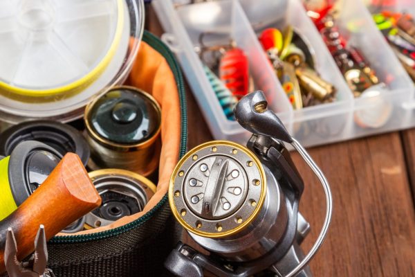 A wooden table with fishing gear and an assortment of baits.