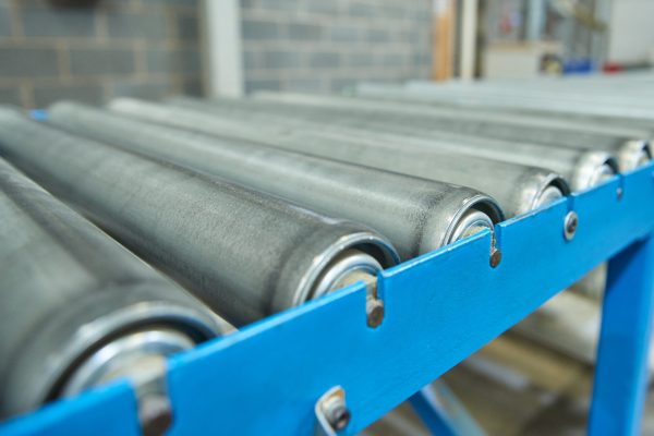 A conveyor belt with metal rollers on it.